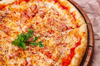 Pastırmalı İtalyan pizzası, domates ve ahşap kesim tahtasında mozzarella peyniri. Kapat.