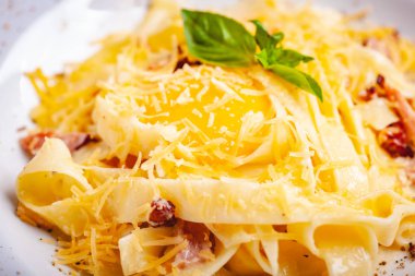 İtalyan mutfağı. Pastırmalı makarna, peynir ve yumurta. Kapat.