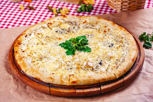 Tahta kesme tahtasının üzerinde İtalyan pizzası (quattro fromaggi). Kapat.