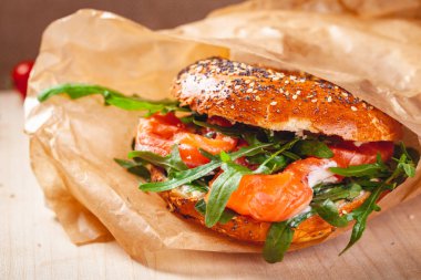 Simit krem peynir, somon füme ve kahverengi kağıt torba roka salatası ile. Yakın çekim