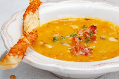 Bezelye çorbası pastırma ile ahşap arka plan üzerinde grisini ile devam eder. Yakın çekim