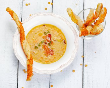 Bezelye çorbası pastırma ile ahşap arka plan üzerinde grisini ile devam eder. Üstten görünüm. Yakın çekim