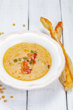 Bezelye çorbası pastırma ile ahşap arka plan üzerinde grisini ile devam eder. Yakın çekim