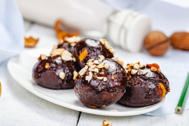 Çikolata sır ve ceviz beyaz tabakta tanımlama bilgisi toplar. Yakın çekim