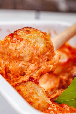 Beyaz güveç çanağı içinde domates ve ekşi krema soslu köfte. Yakın çekim