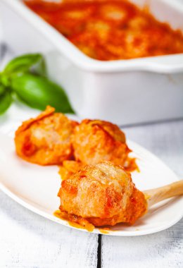 Beyaz tabakta domates ve ekşi krema soslu köfte. Yakın çekim