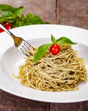 İtalyan makarna beyaz plaka üzerinde ev yapımı pesto soslu spagetti. Yakın çekim