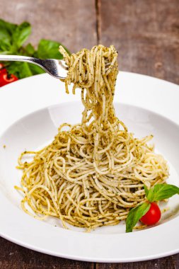 İtalyan makarna beyaz plaka üzerinde ev yapımı pesto soslu spagetti. Yakın çekim