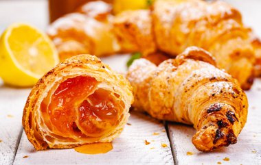 Limonlu kruvasanları Beyaz ahşap arka plan üzerinde reçel. Yakın çekim