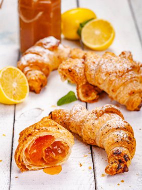 Limonlu kruvasanları Beyaz ahşap arka plan üzerinde reçel. Yakın çekim