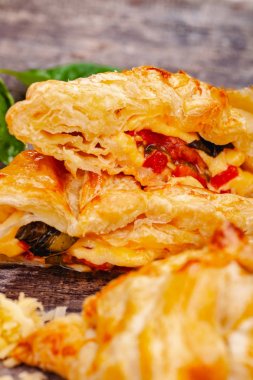 Puf böreği kiraz domates, mozzarella peyniri ve fesleğen ahşap rustik masa üzerinde. Yakın çekim