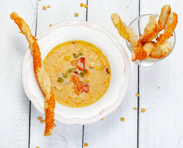 Bezelye çorbası pastırma ile ahşap arka plan üzerinde grisini ile devam eder. Üstten görünüm. Yakın çekim