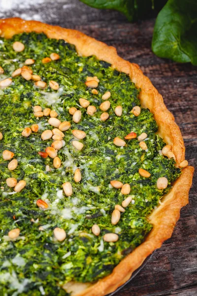 Ispanak, ricotta peyniri ve çam fıstığı ahşap rustik masa üzerinde tart. Yakın çekim