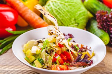 Beyaz plaka üzerinde farklı sebze ile soğanlı salata