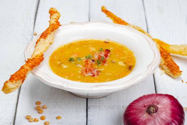 Bezelye çorbası pastırma ile ahşap arka plan üzerinde grisini ile devam eder. Yakın çekim