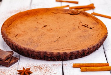 Ahşap rustik masa üzerinde tarçın ile çikolatalı pasta. Yakın çekim