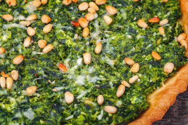 Ispanak, ricotta peyniri ve çam fıstığı ahşap rustik masa üzerinde tart. Yakın çekim