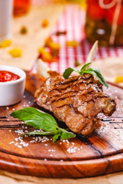 Ahşap tahtada aromatik zeytinyağı, otlar ve baharatlarla kızartılmış kuzu eti. Kapat.