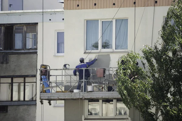 Ressam, sıvacı özel giysili bir rulo beşikteki bir yükseklikte bina cephe boyalar. Yüksekliği onun güvenliğini koruyan özel bir donanım ile bir kişinin çalıştığı