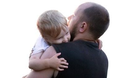 Küçük bir çocuk babası silah koruma arıyor. Çocuk gizler ve inanmazlıkla babasının omuz üzerinden görünüyor.