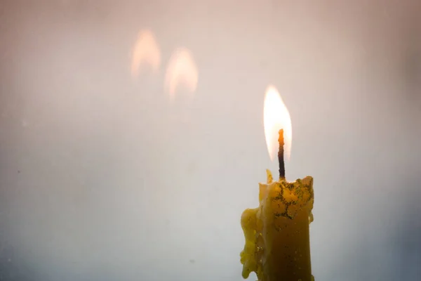 Sarı bir mum pencere camı duruyor. Mum alevi penceresinde yansıtılır. Sonsuz ateşe bakabilirsiniz. Bir mum ışığı ve ölülerin hatırlıyorum zaman