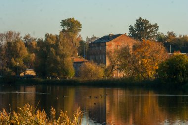 Sonbahar renkleri gölde önünde nehrin karşısındaki bina eski tuğla yüksek katlı görünümünü