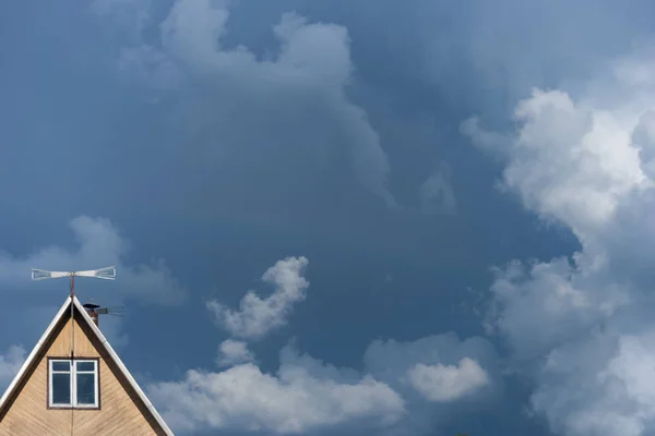 风暴前的天空和云的背景是一个农村房屋的三角形屋顶 深蓝色的云 逐渐充满了整个天空 — 图库照片