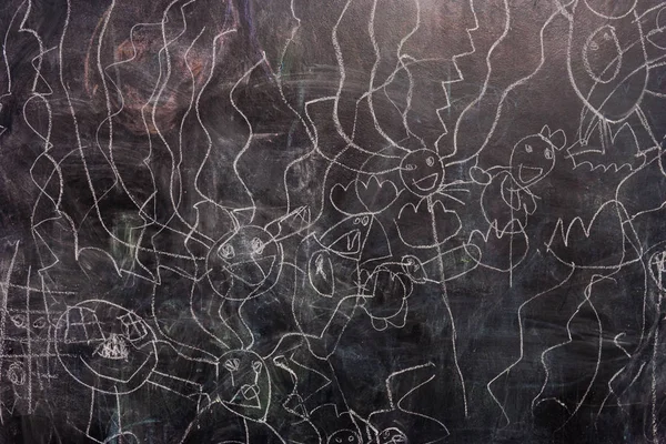 Çocuk çizimleri tebeşir siyah tebeşir tahtası. İnsanlar çocuk tarzı. Daireler ve sopa - gelecekteki sanatçılar tarafından çizimler.