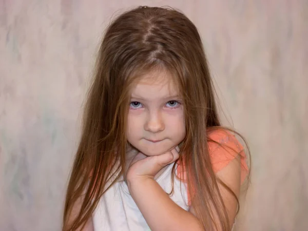 Isırıldı dudak kameraya poz biraz yorgun kızla. Soluk bebek acı tür ayakta ve görüntüleyiciyi seyir.