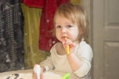 Küçük bir kız çocuğu kirli bir diş macunu sıçramış ayna aracılığıyla görüntüleyin. Çocuk dişlerini fırçalar, ilk süt dişleri kargaşa içinde her şeyin yerini banyoda plak kaldırır.