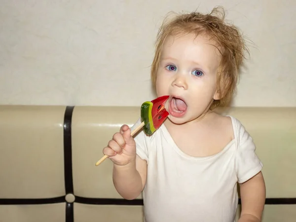 Little Disheveled Blue Eyed Girl Baby White Body Tastes Candy — Stock Photo, Image