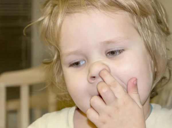 可爱的小男孩有一个坏习惯 孩子摘下鼻子 试图从鼻窦里得到干涸的沙皮 摆脱孩子不良习惯的原因和方法是什么 — 图库照片