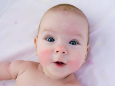 Küçük neşeli bebek kız bebek ve hava banyoları, daldırma cilt güneş alır. Bebek kızarıklık yanaklarda, soğuktan benzer vardır..