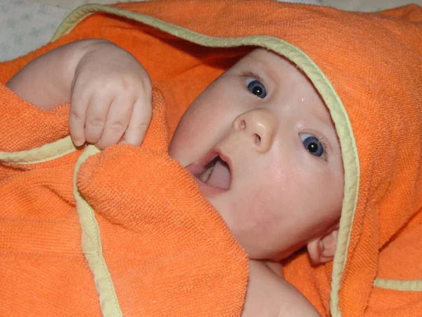 小女婴宝宝玩橙色毛巾 洗澡后 婴儿被用毛巾包裹 以保暖 — 图库照片
