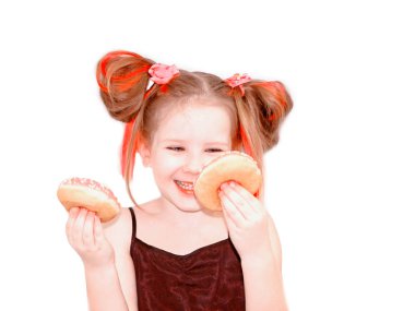 Küçük mutlu sevimli kız pembe arka plan duvar üzerinde donut yiyor. Çocuk eğlenceli poğaça ile geçiriyor. Çocuklar oynamak için lezzetli yemekler. Tatlı gıda ile komik zaman. Pembe saçları parlak bebek kız.