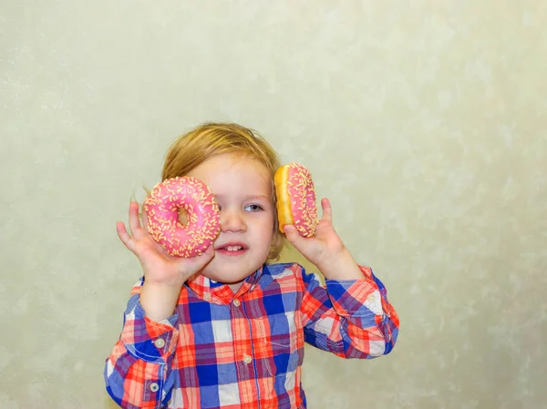 Een Kleine Jongen Jongen Grasduint Speelt Met Twee Verse Donuts — Stockfoto