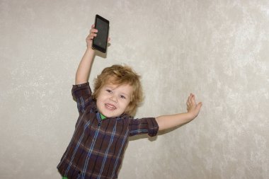 Biraz Toddler çocuk başının üstünde bir smartphone Gadget alır. Memnun bir çocuk onun Smartphone ile telefonlar oynamak için izin verildi mutlu.