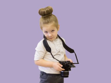 İş kıyafetleri giyen küçük bir kızın elinde bir refleks kamera var. Çocuk fotoğraf çekmeyi öğrenir ve elindeki zor tekniği öğrenir..