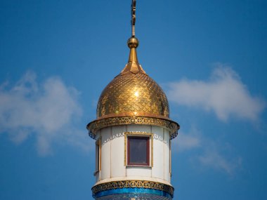 Ortodoks kilisesinin bir parçası olan parça, sudaki balık pulları gibi güneşte mavi çatısıyla parıldıyor. Ortodoks inancının beyaz kilisesinin güzel binası güneşte parlıyor.