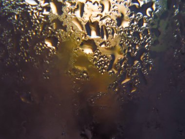 Kahverengi arka plan üzerinde cam bölmeye damlalar