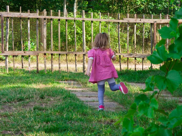 Evin yakınındaki bahçede oynayan küçük kız bebek.