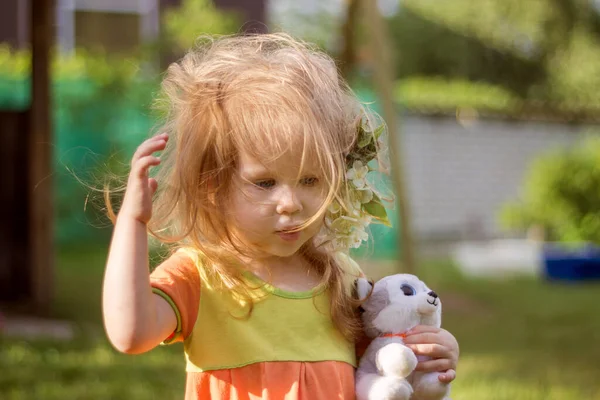 Μπερδεμένο παιδί με υπέροχα μαλλιά με σκυλάκι στα χέρια του στην αυλή.. — Φωτογραφία Αρχείου