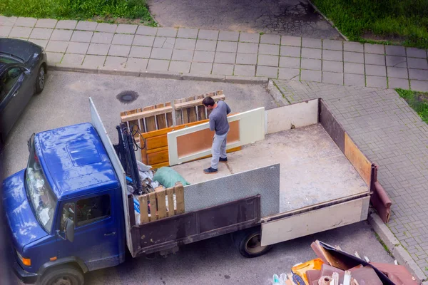 Los trabajadores cargan muebles viejos en la parte trasera de un camión para transportar — Foto de Stock