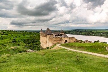 Ukrayna 'daki Khotyn Kalesi, yazın bulutlu bir günde kara bulutların arka planında nehir. Yatay yönelim.