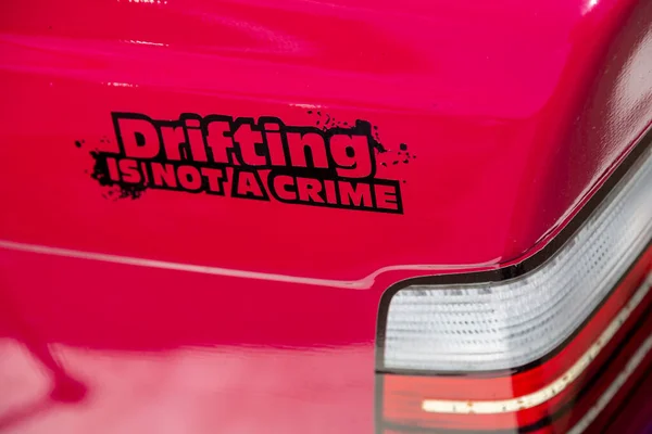 标有浮动车字样的贴纸在尾灯附近的跑车红色车身上不构成犯罪。特写。横向方向：. — 图库照片