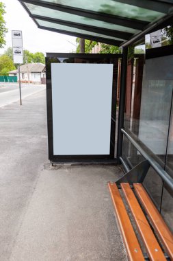 Tramvay otobüsü toplu taşıma durağında beyaz boş reklam afişi. Dikey yönelim. 