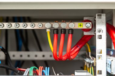 Pozitif otobüse bağlı elektrik kabloları. Kırmızı kablolar ve yer. Yatay yönelim.