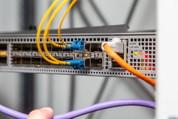 Волоконно-оптичні жовто-блакитні кабелі підключаються до роз'єму даних. Горизонтальна орієнтація . — стокове фото