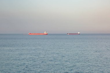 Sakin deniz, gökyüzü ve ufukta iki mavna. Yatay yönelim.