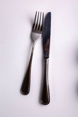 Çatal ve bıçak beyaz arka planda yatar. Yukarıdan bak. Dikey oryantasyon. Yüksek kalite fotoğraf